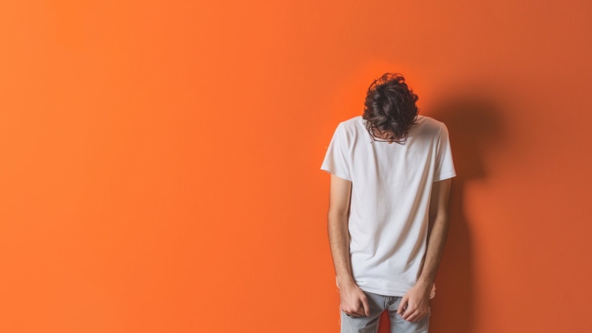 Guy standing alone feeling sad thinking 'why am I not good at anything?'