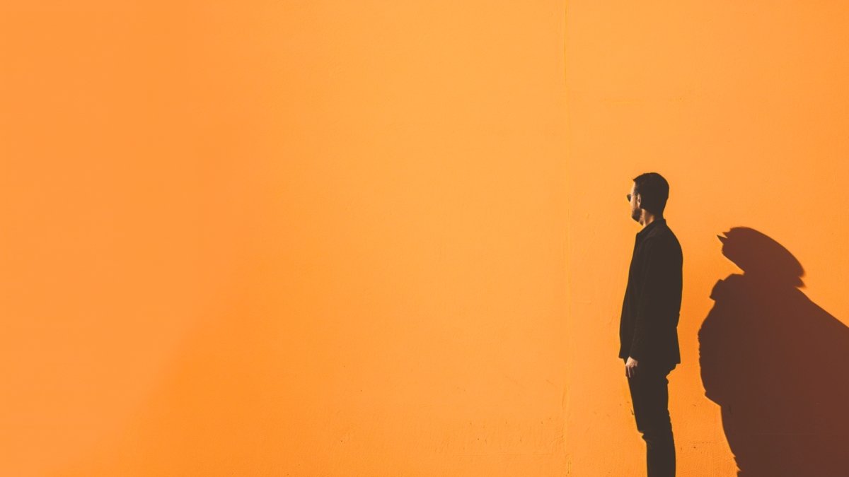 Man standing near a wall thinking of moving forward in life