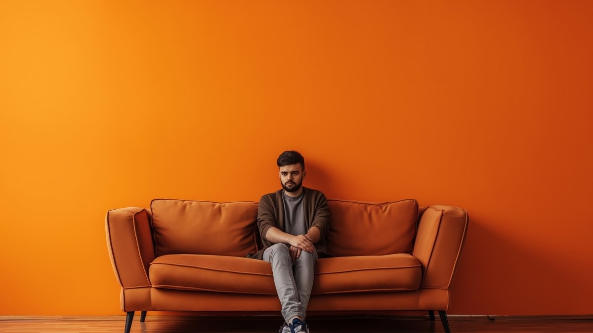 A man sitting on sofa feeling unfulfilled 