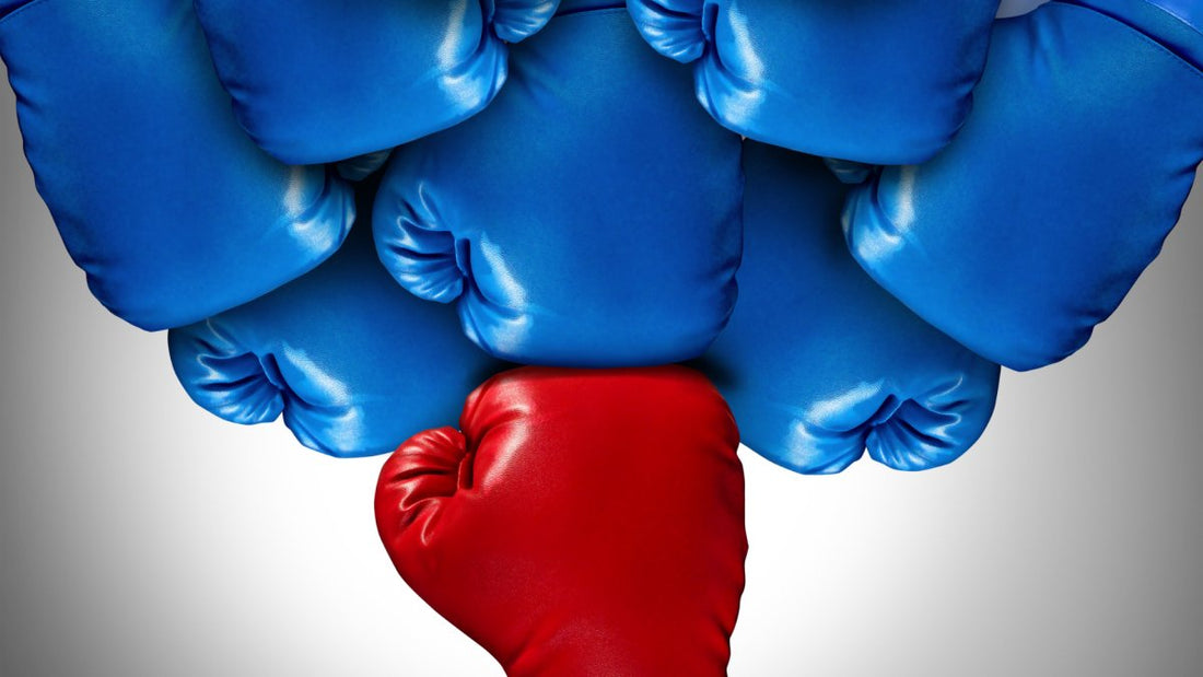 one red boxing glove holding back numerous blue boxing gloves