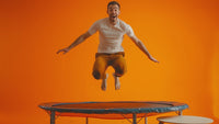a happy man jumping above trampoline