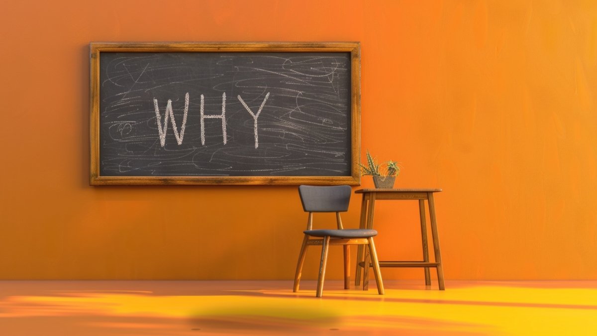 "WHY" written on a blackboard on the wall in a room