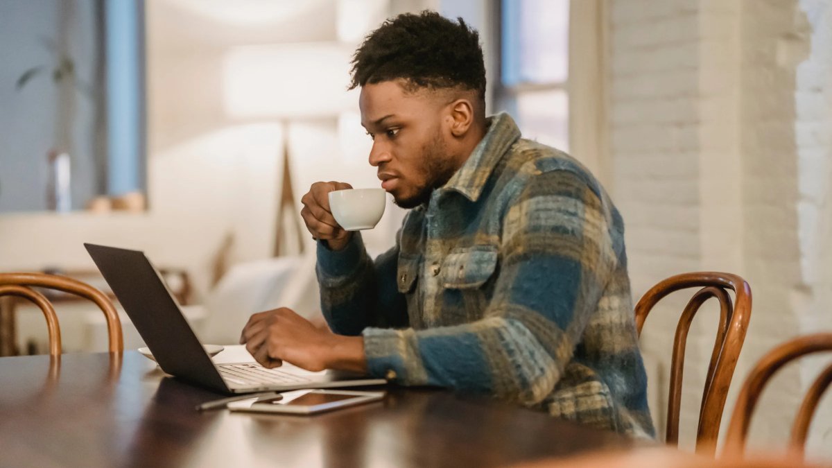 man working on laptop, holding a cup, focused on what he can control