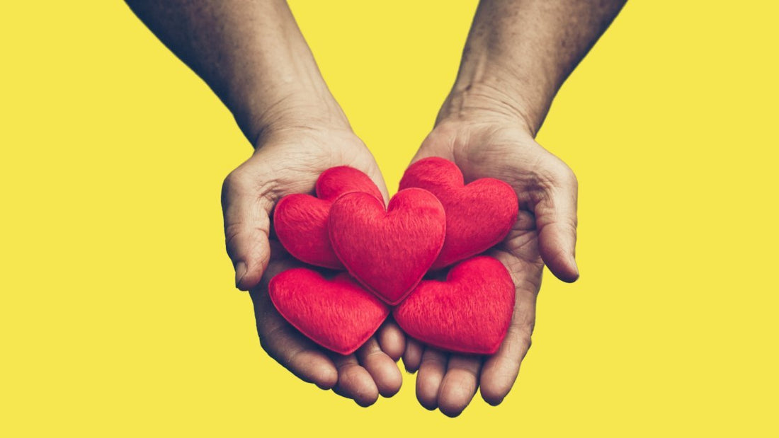 two hands giving small pillow hearts, with a yellow background