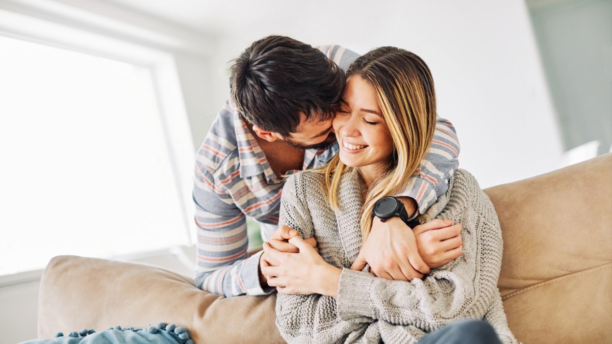 happy couple moving forward hugging on the couch