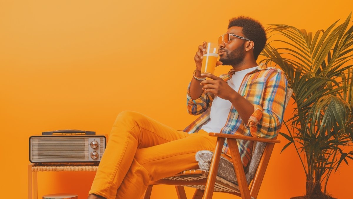 A chill man sitting on a chair listening to radio and enjoying his mocktail