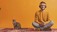 Man sitting on the floor beside his cat listening to 'I Am Affirmations'