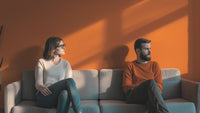 A couple sitting in sofa dealing with avoidant attachment trigger