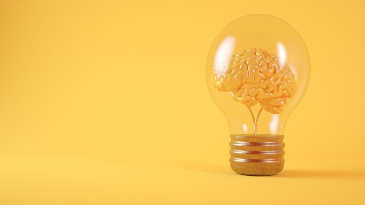 brain mind inside a light bulb, yellow background