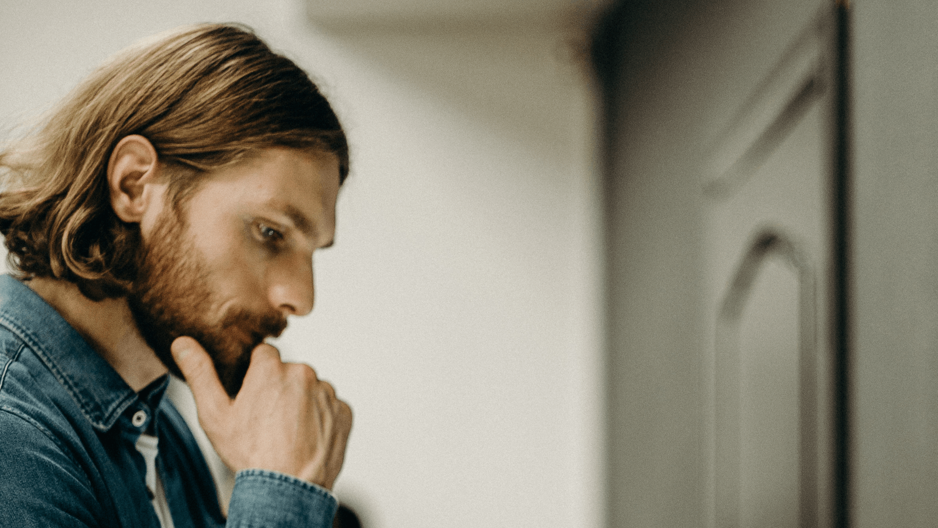 man holding his chin overthinking