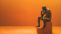 A sculpture of a man sitting and thinking used to explain personal philosophy