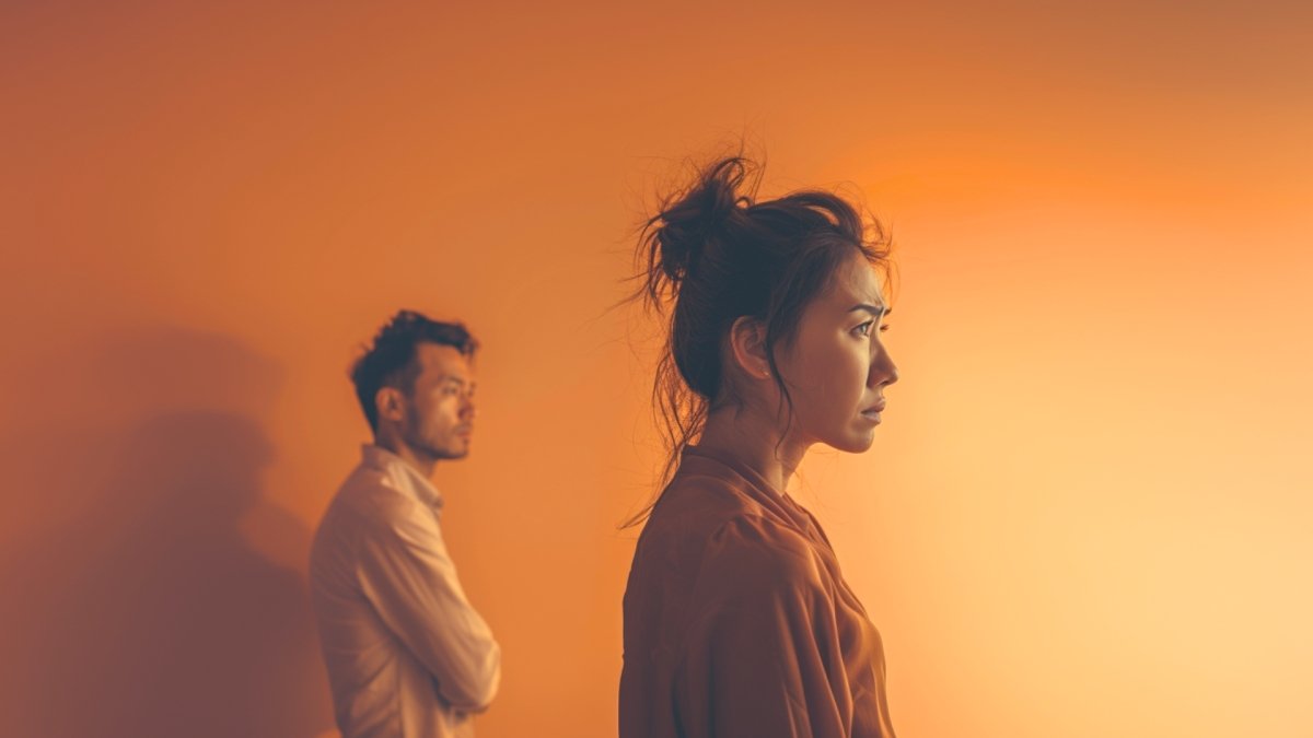 A man and a woman standing away from each other because of strain in relationship