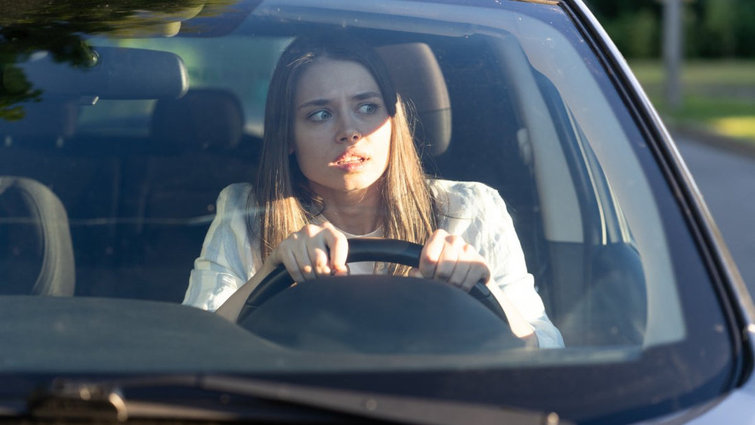 woman driving, looking worried to the side