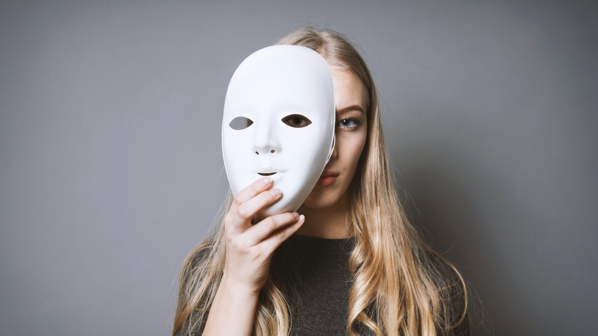 woman wearing a mask in fron her face showing two personalities bipolar and optimistic