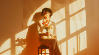 Girl sitting on a chair holding flowers, taking herself on a date
